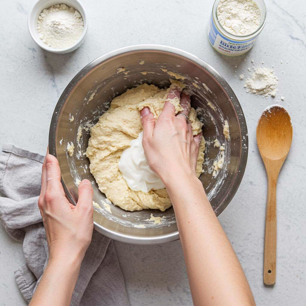 Gluten free flatbread dough being kneaded in a bowl